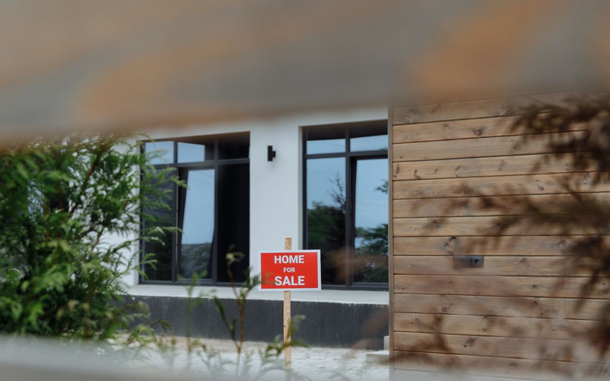 A Home For Sale sign in front of a house